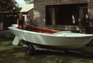 Karl and Adam sitting on the back of Grandad's first sailboat in front of their home in Ohio.