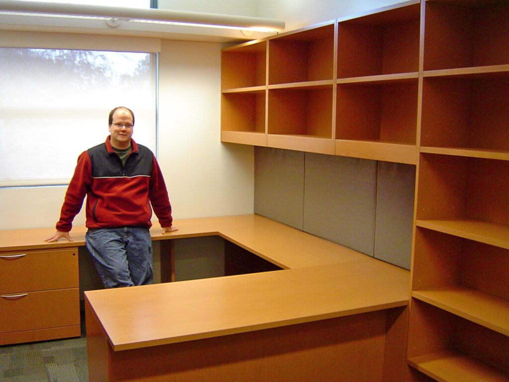 Karl standing in his empty office before he moved in to Pomona College