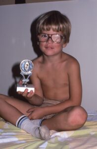 Karl with glasses and an eyepatch, holding a 2nd place trophy (presumably for 2nd best eyepatch).